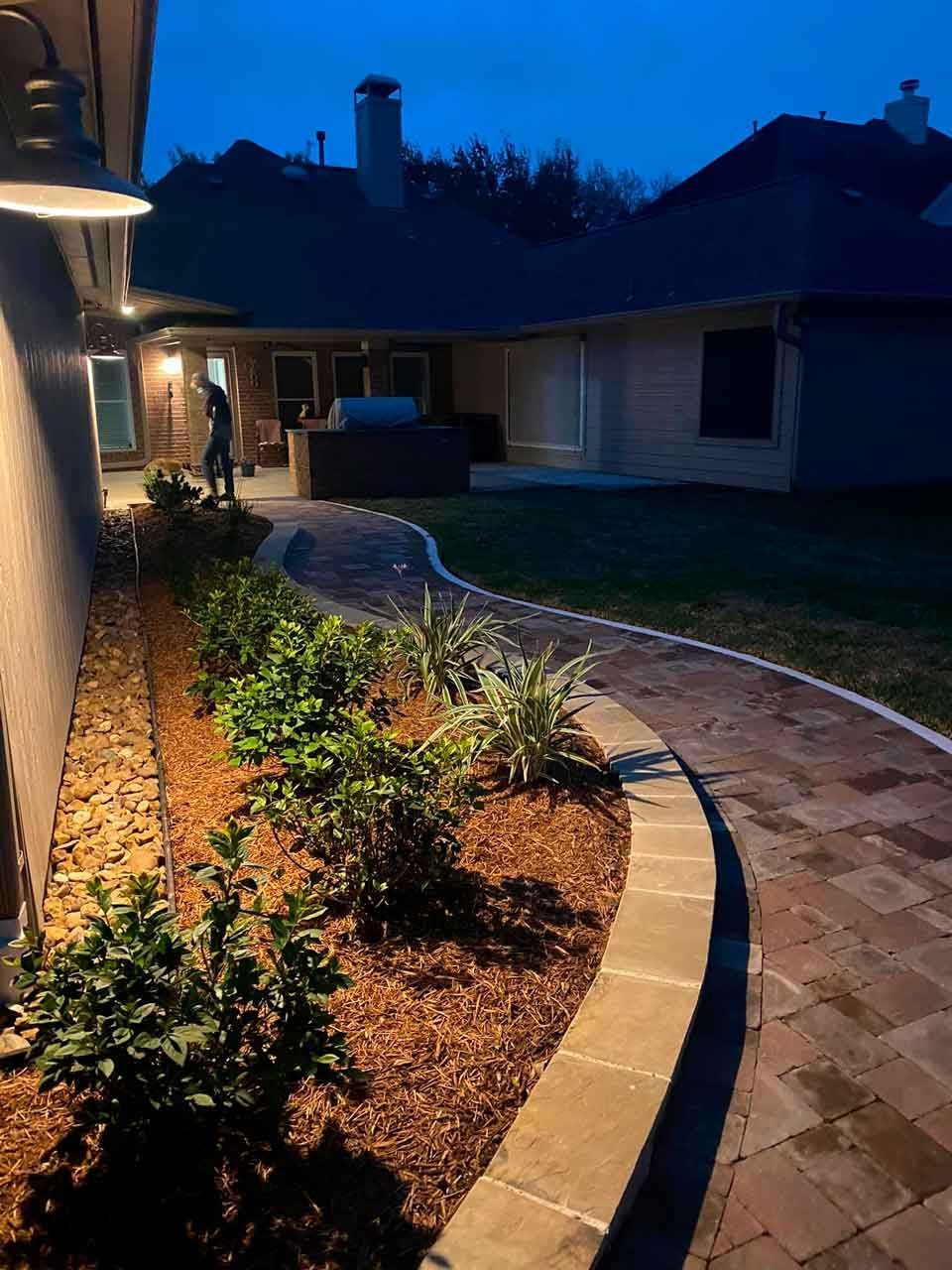 Brick pathway and landscaping of stones and plants