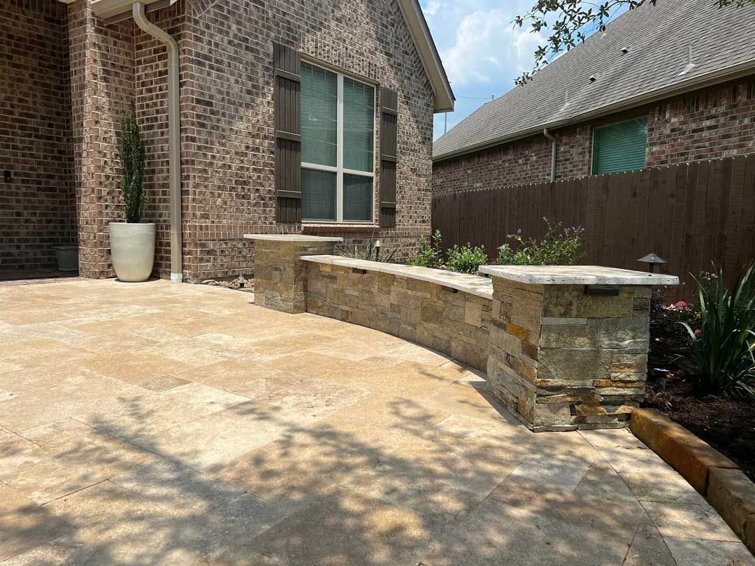 Glossy limestone patio with small stone wall