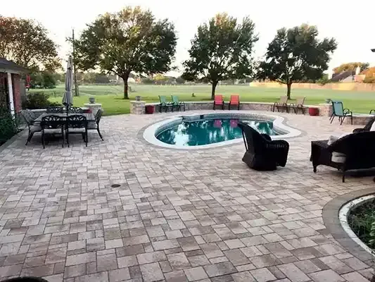 there is a large swimming pool in the middle of the backyard .