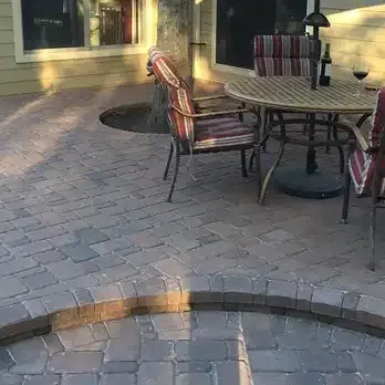 a patio with a table and chairs and a bottle of wine .