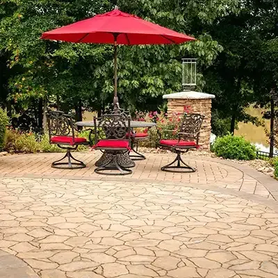 a patio with a table and chairs and a red umbrella .