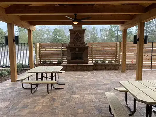 a picnic area with tables and benches and a fireplace .