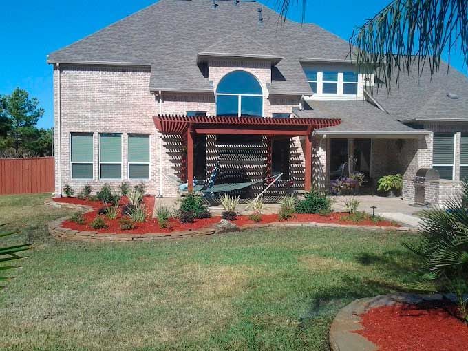 Backyard outdoor Attached Pergola with beautiful landscaping beds