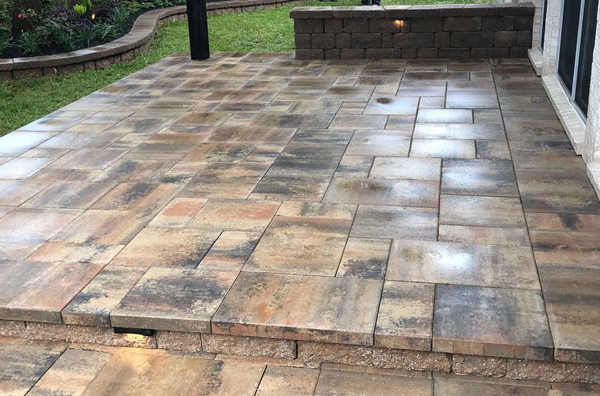 Backyard limestone patio covered with a pergola