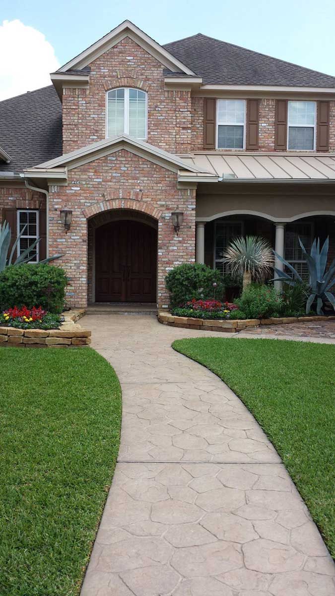 Pathway of light stones with grass and landscaping for appeal