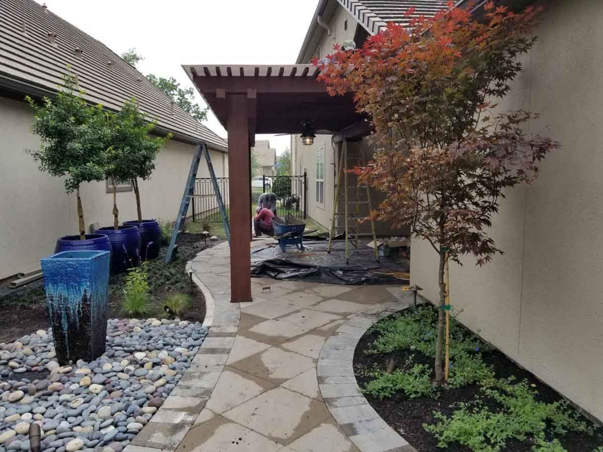 Stone pathway with cedar pergola at the entrance of the house