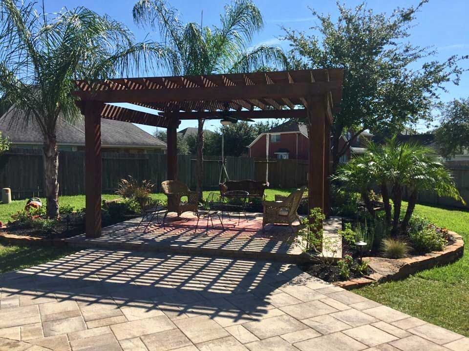 Timber pergola in a backyard with paver area and palm trees