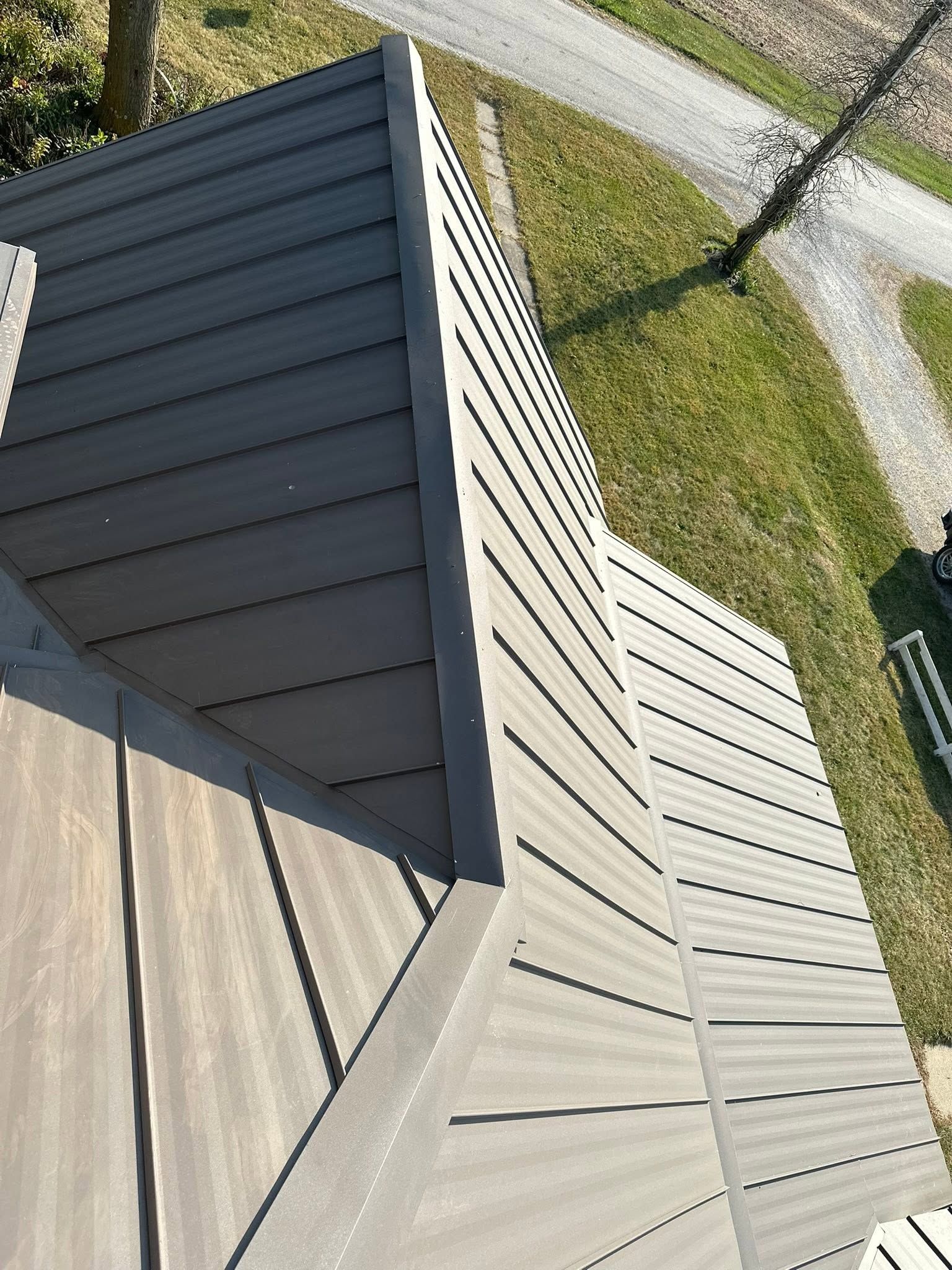Close-up of dark roof shingles with sunlight glinting in the background