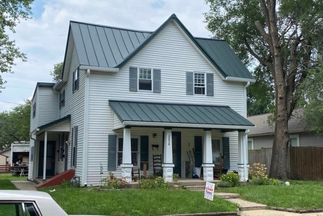 Two-story white house with gray roof and front porch in a grassy yard