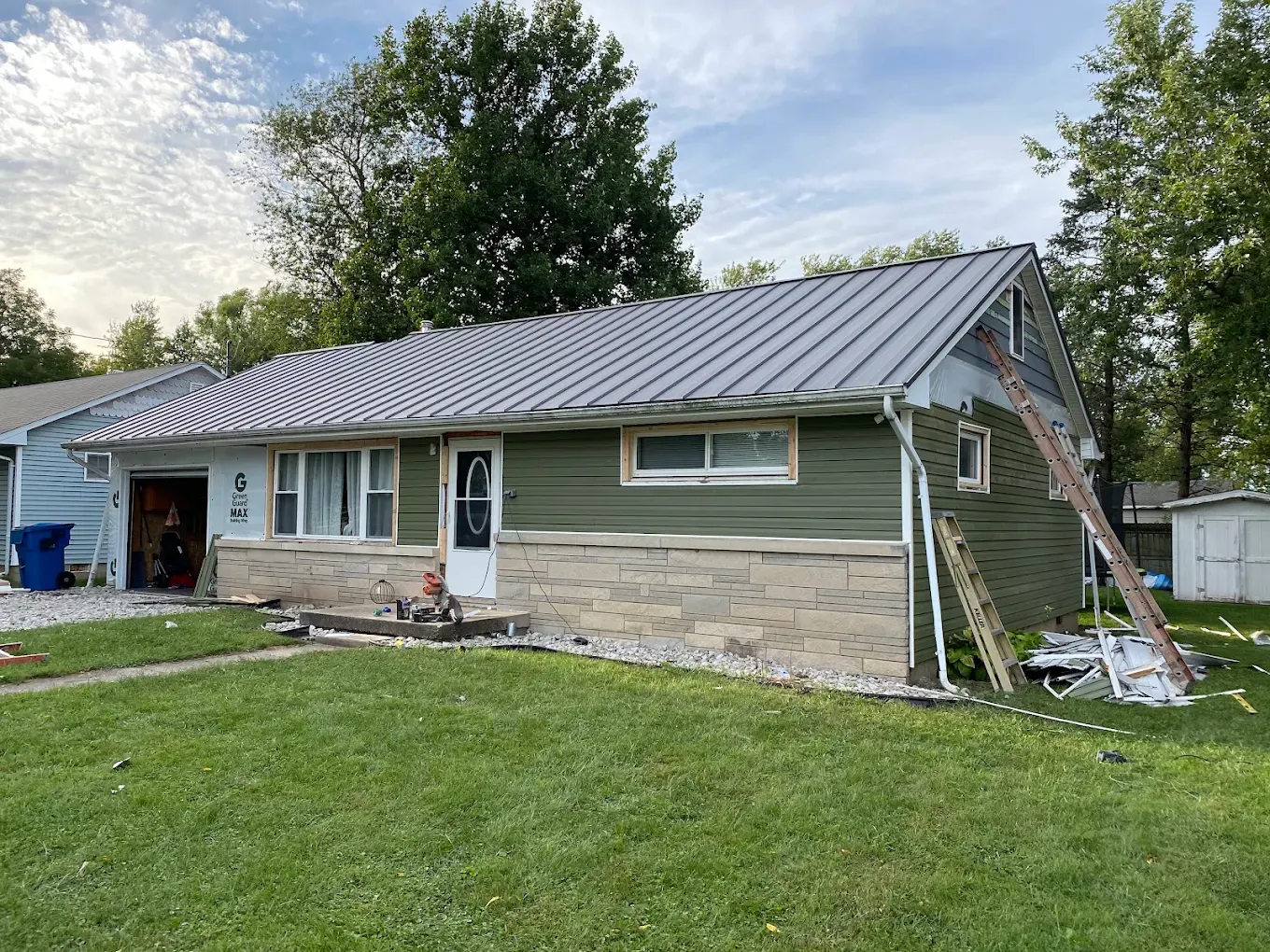 Damaged brown shingle roof with missing and torn shingles, exposing the roof underneath.