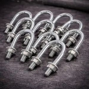 Accesorios de fontanería metálicos y conectores de tuberías roscadas apilados sobre una superficie, vista de cerca.