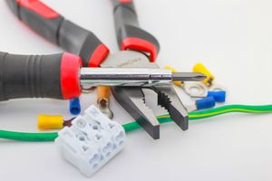 Accesorios de fontanería metálicos y conectores de tuberías roscadas apilados sobre una superficie, vista de cerca.