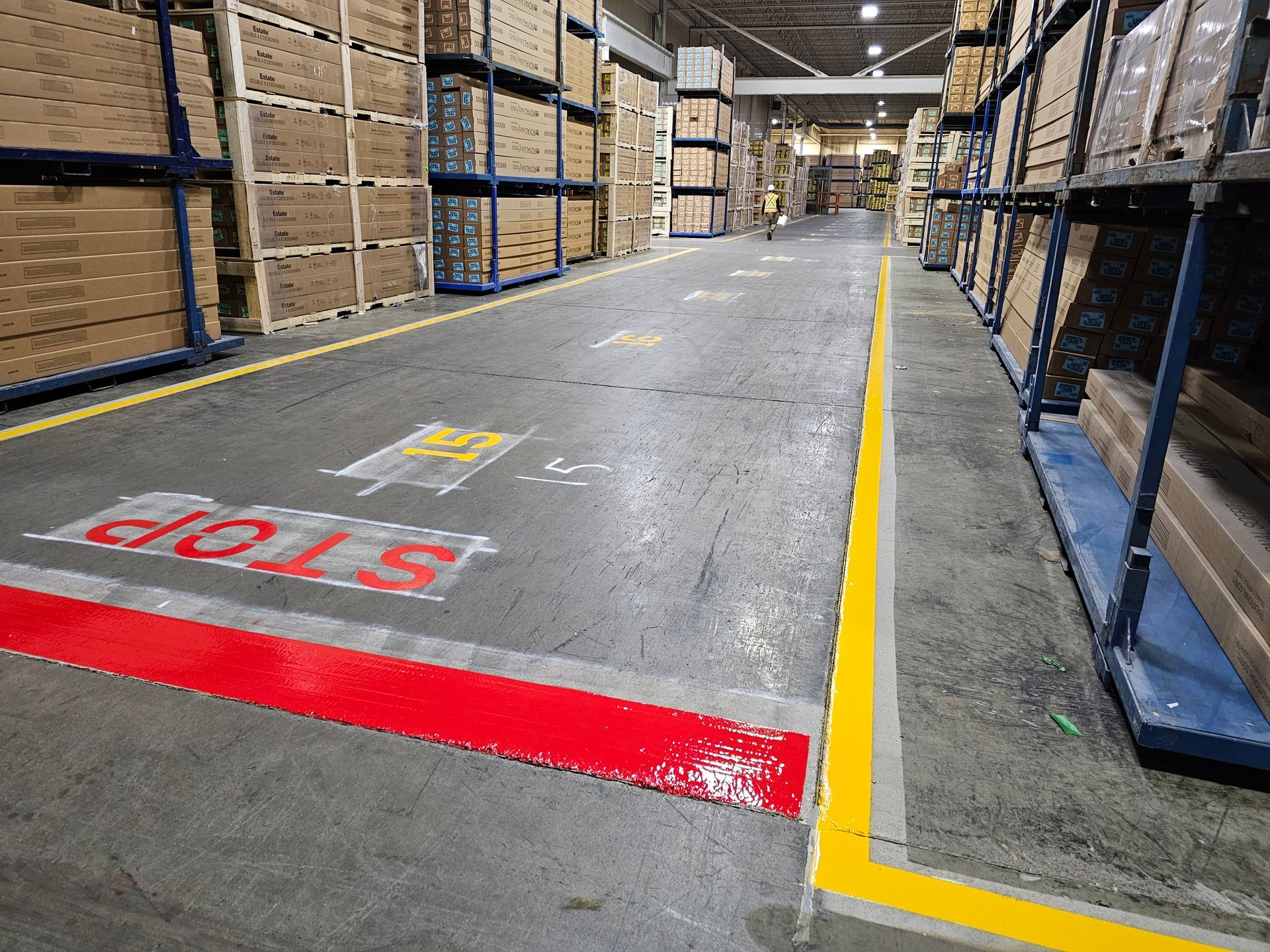 Warehouse aisle with concrete floor marked with a red 