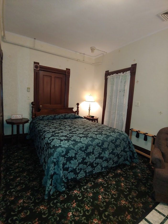 A bedroom with a bed and a chair in it