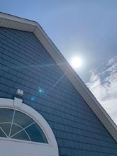 The sun is shining brightly on the roof of a house