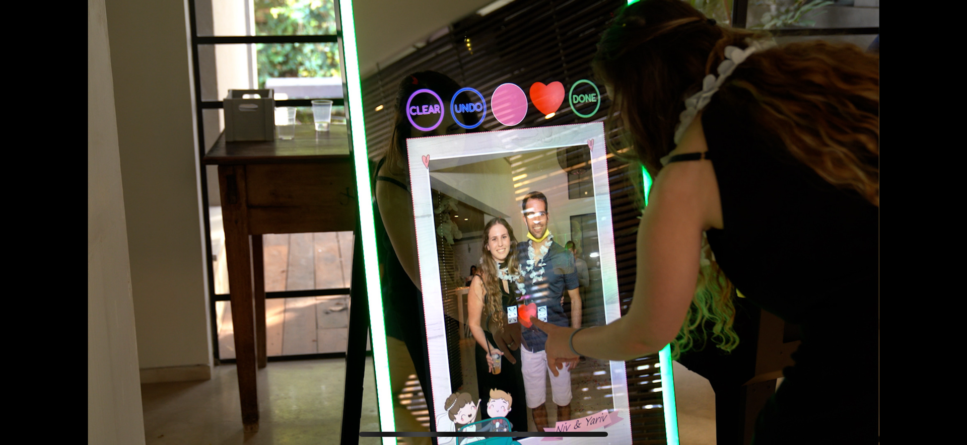 couple posing in front of mirror photo booth