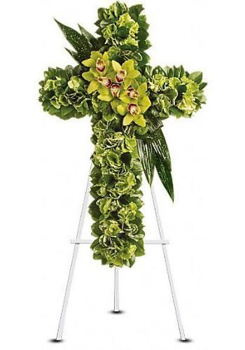 Cross-shaped floral arrangement with green leaves and white flowers on a white stand