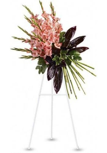 Pink floral arrangement on a tall white tripod stand with dark leaves