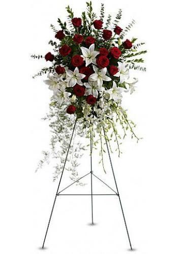 Tall white and red floral funeral spray on a black metal stand