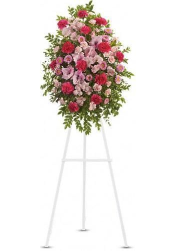 Pink and red floral wreath on a white metal easel stand