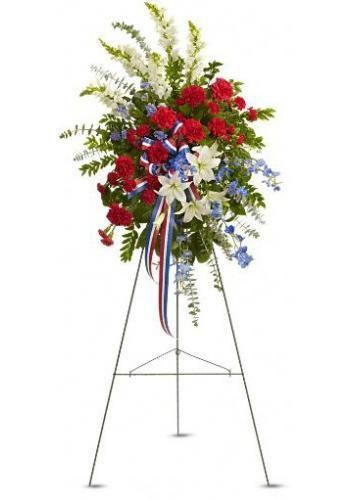 Tall floral arrangement of red, white, and blue flowers on a metal stand with ribbons