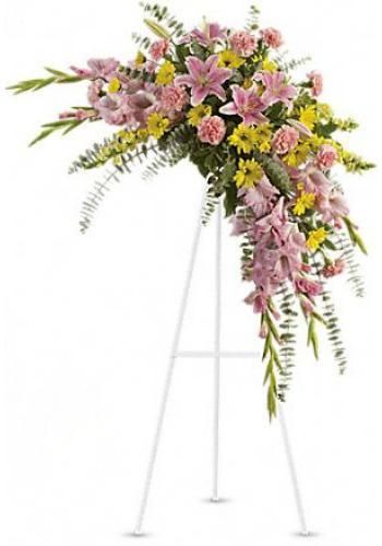 Pink and yellow floral spray on a white easel stand