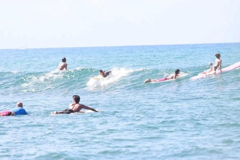 People swimming and floating in the ocean under a bright sky