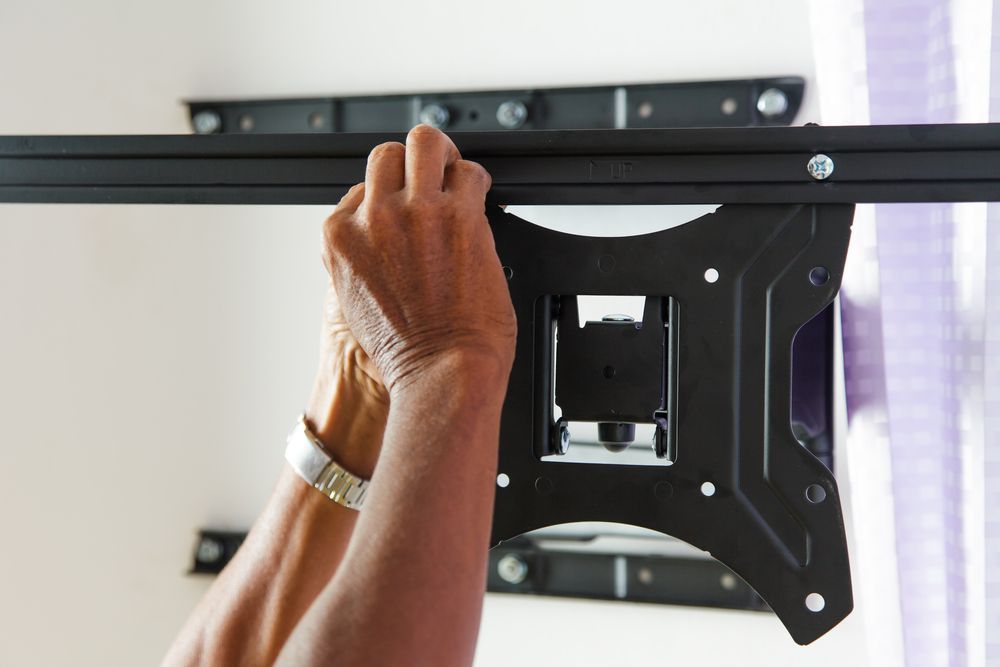 Man Installing Mount TV On The Wall At Home โ Stand Fast Electrical Pty Ltd in Warwick, QLD