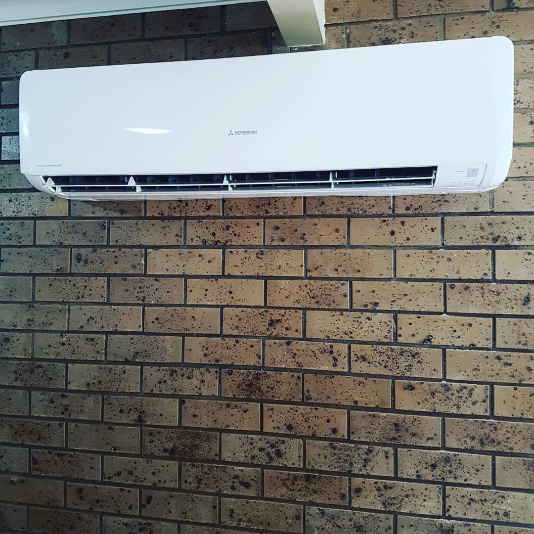 White Air Conditioner Hanging On A Brick Wall โ Stand Fast Electrical Pty Ltd in Warwick, QLD
