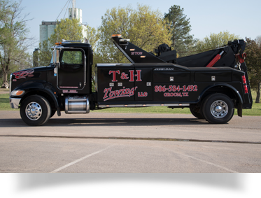 Black tow truck with red lettering;