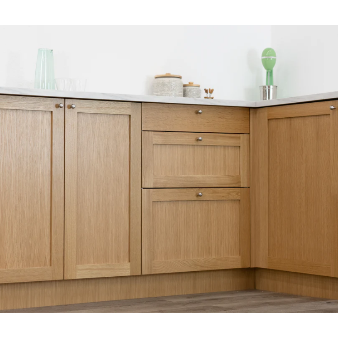 A kitchen with wooden cabinets and drawers and a white counter top