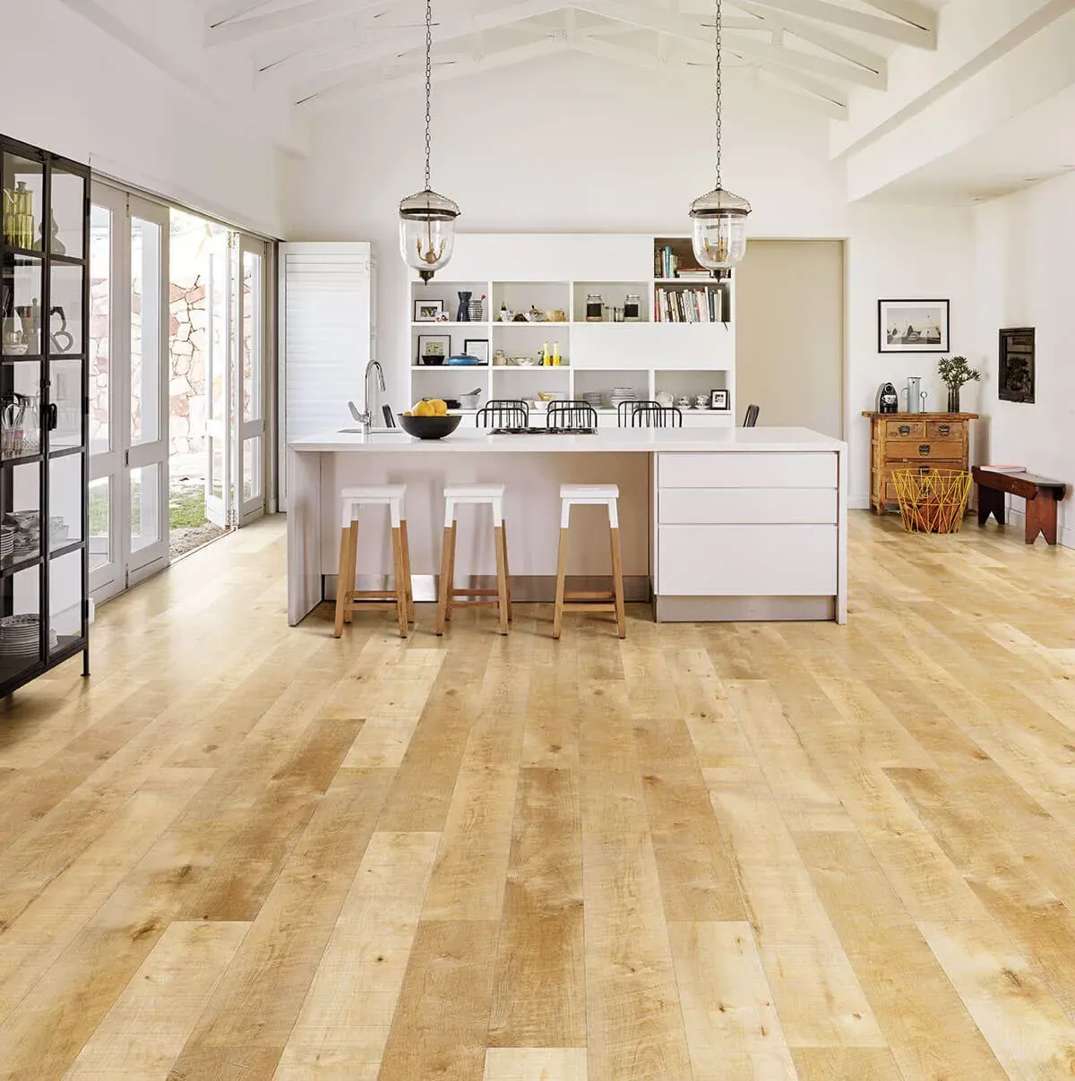 A kitchen with wooden floors and white cabinets