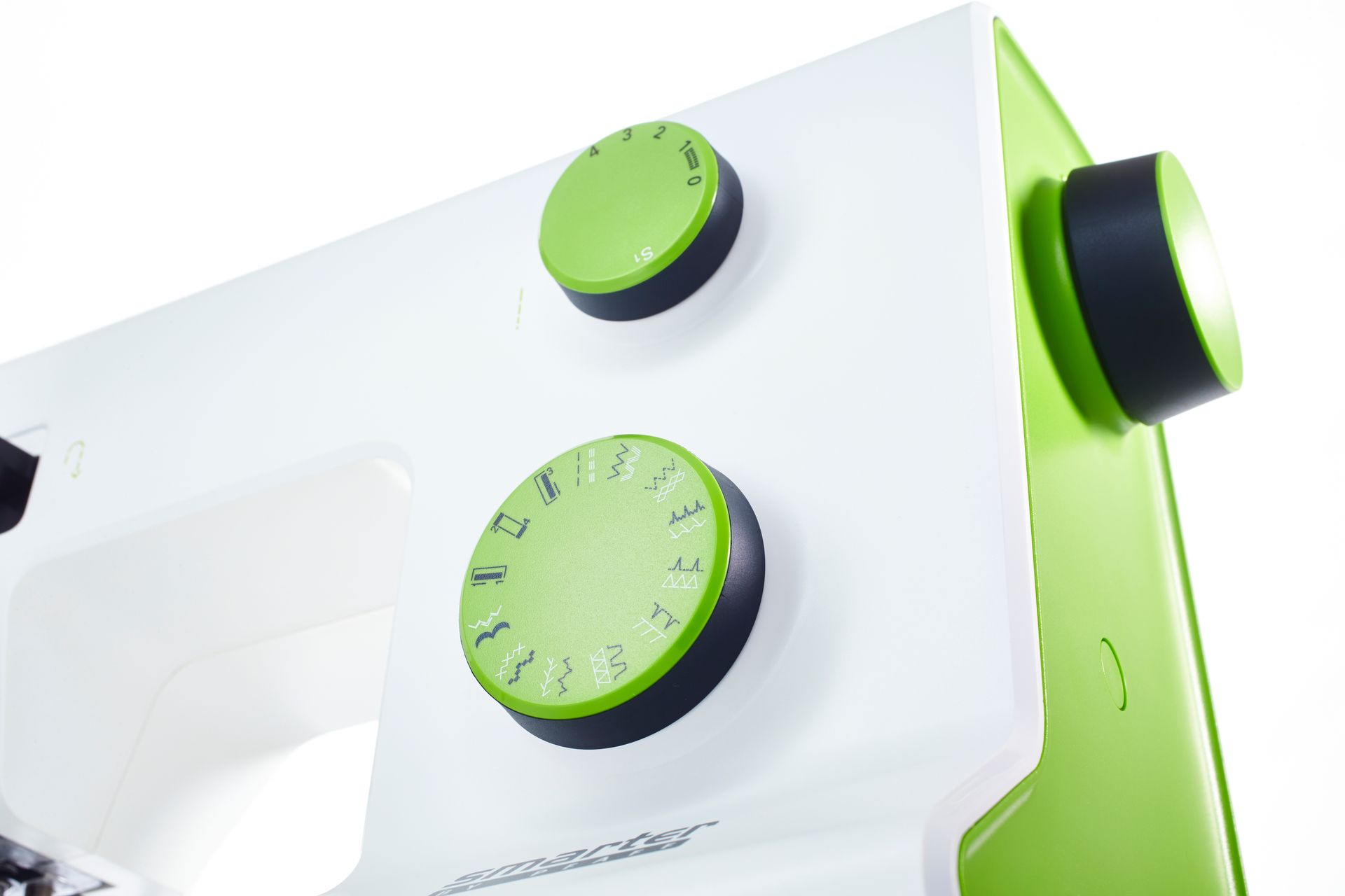 Close-up of a white and lime-green appliance with two green control knobs