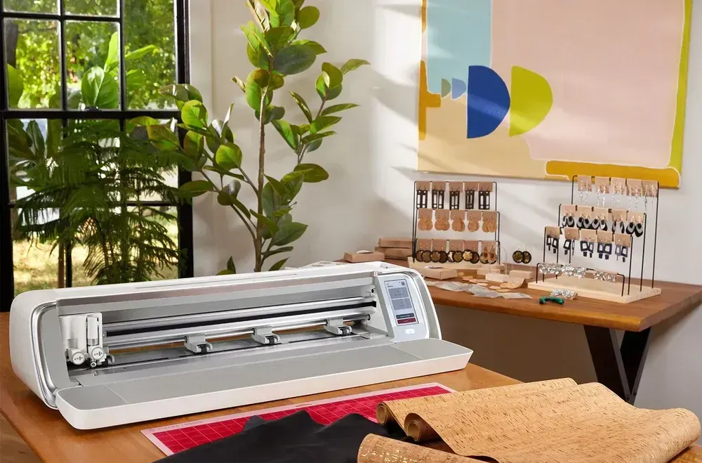 A cutting machine is sitting on top of a wooden table.
