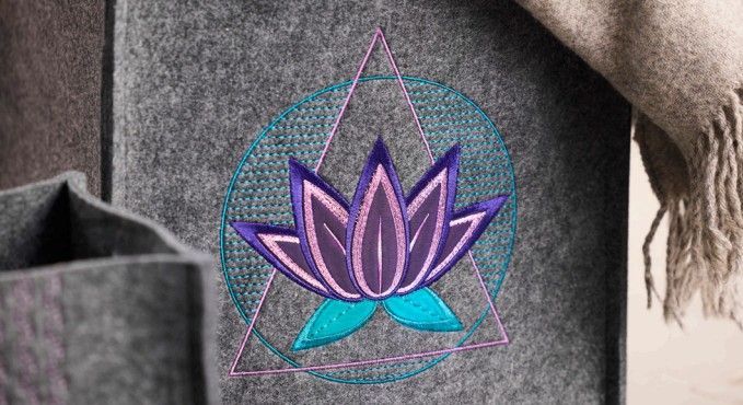 A gray bag with a lotus flower embroidered on it.