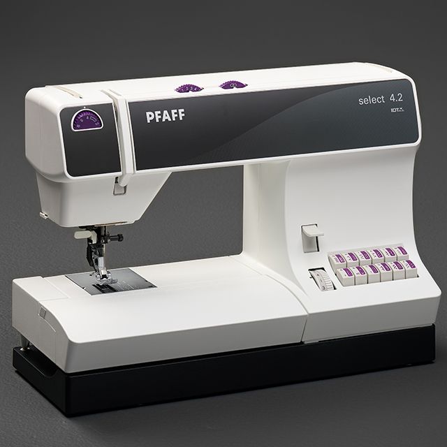 A white pfaff sewing machine with purple buttons