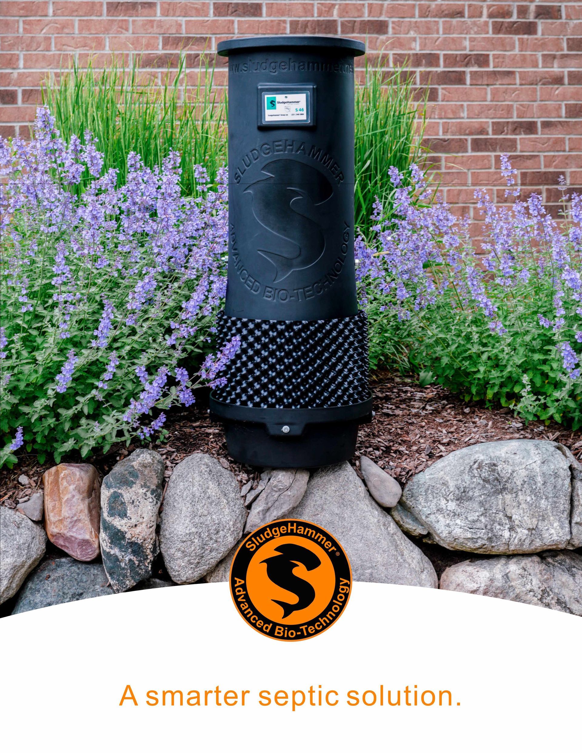A black septic vent pipe stands in a garden bed with purple flowers, with a logo and text: A smarter septic solution.
