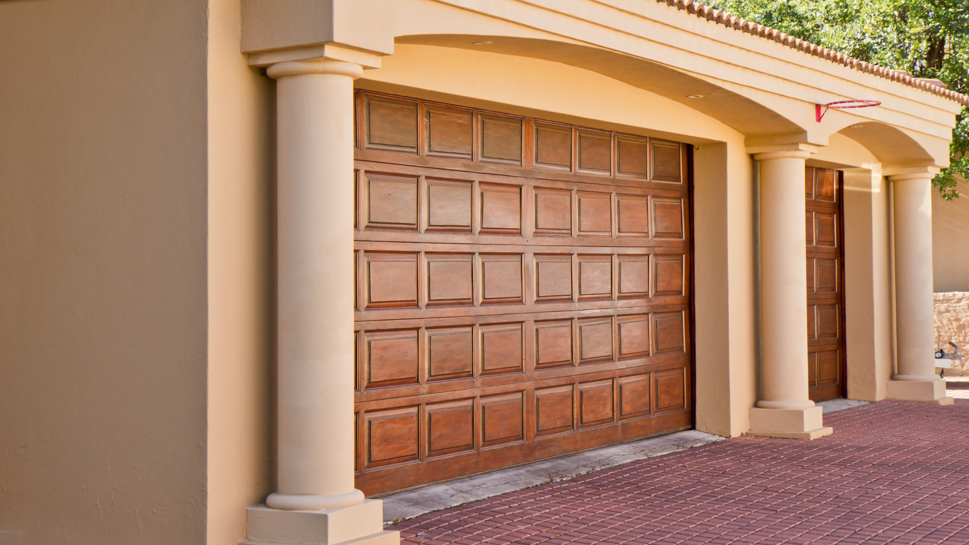 A row of wooden garage doors on a house with columns.