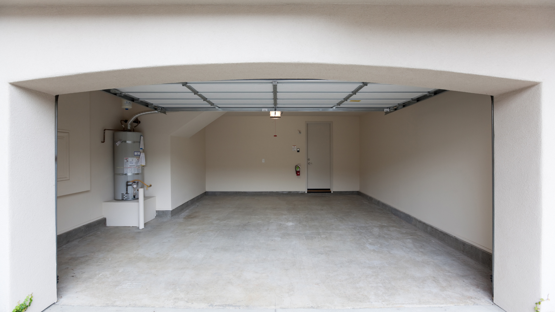 An empty garage with a water heater in it.