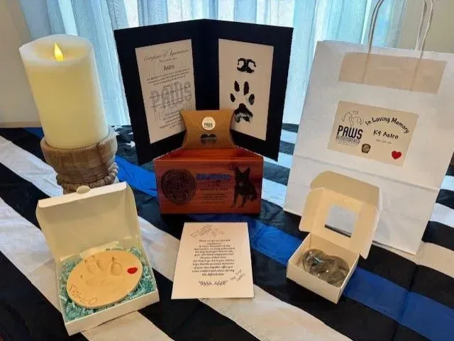 Blue-and-white tabletop display of assorted handmade crafts, cards, candle, and small boxes