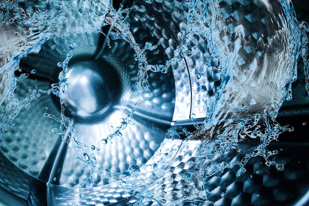 Primo piano di un'immagine astratta blu metallizzata con un centro circolare riflettente e motivi geometrici texturizzati.