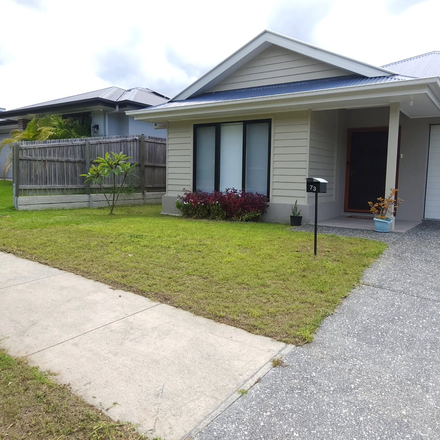 Single-story suburban house with a small front lawn, driveway, and covered porch