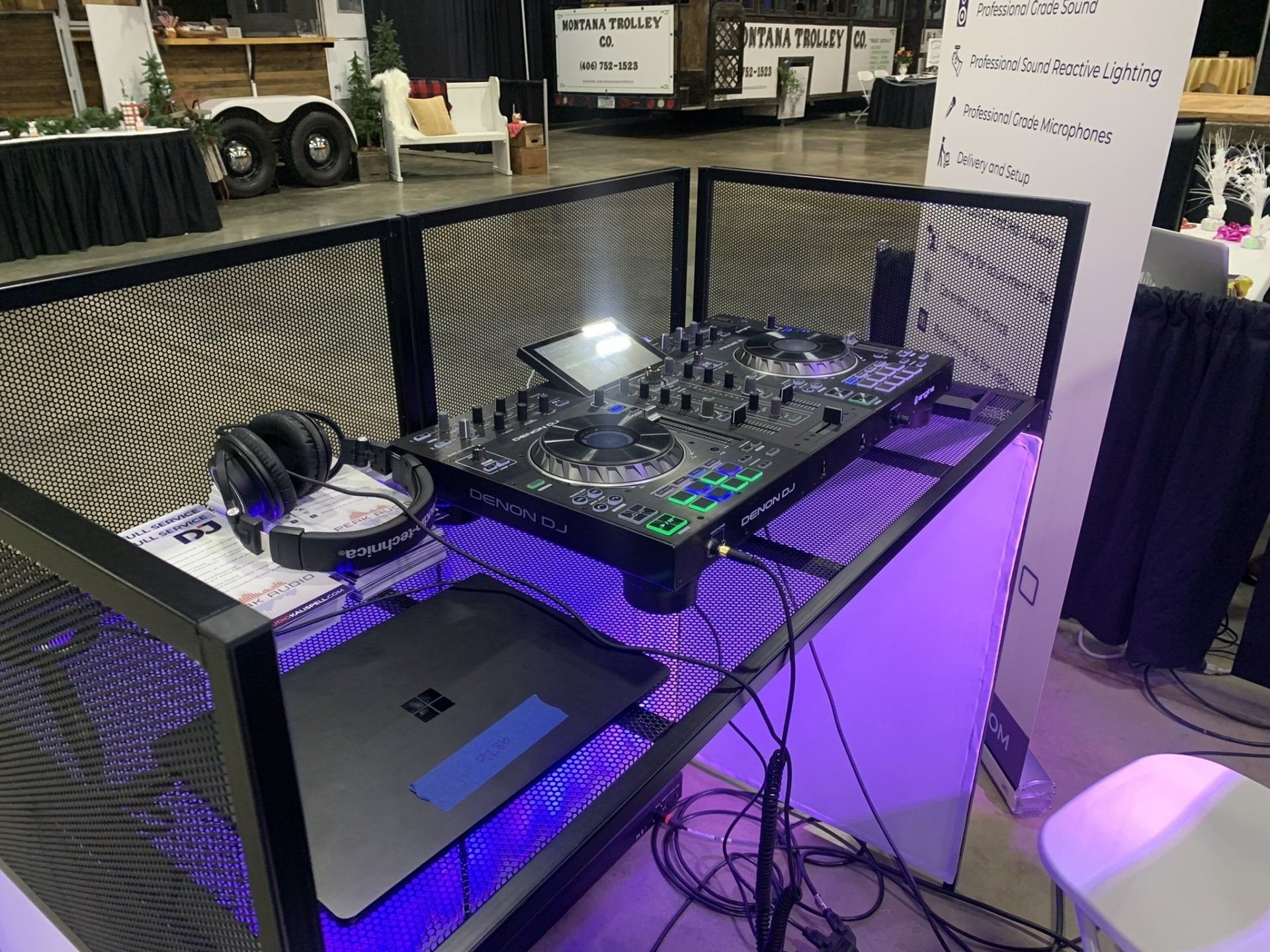 A dj booth with a laptop and headphones on it.