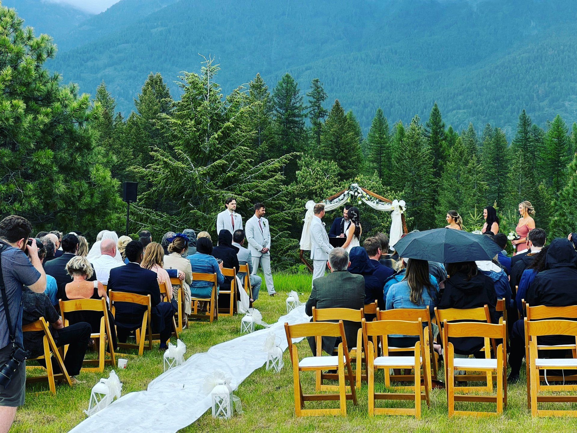 A large group of people are sitting in chairs at a wedding ceremony.