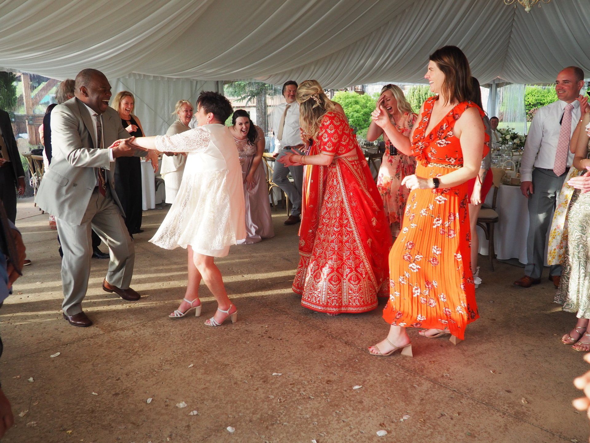 A group of people are dancing under a tent.