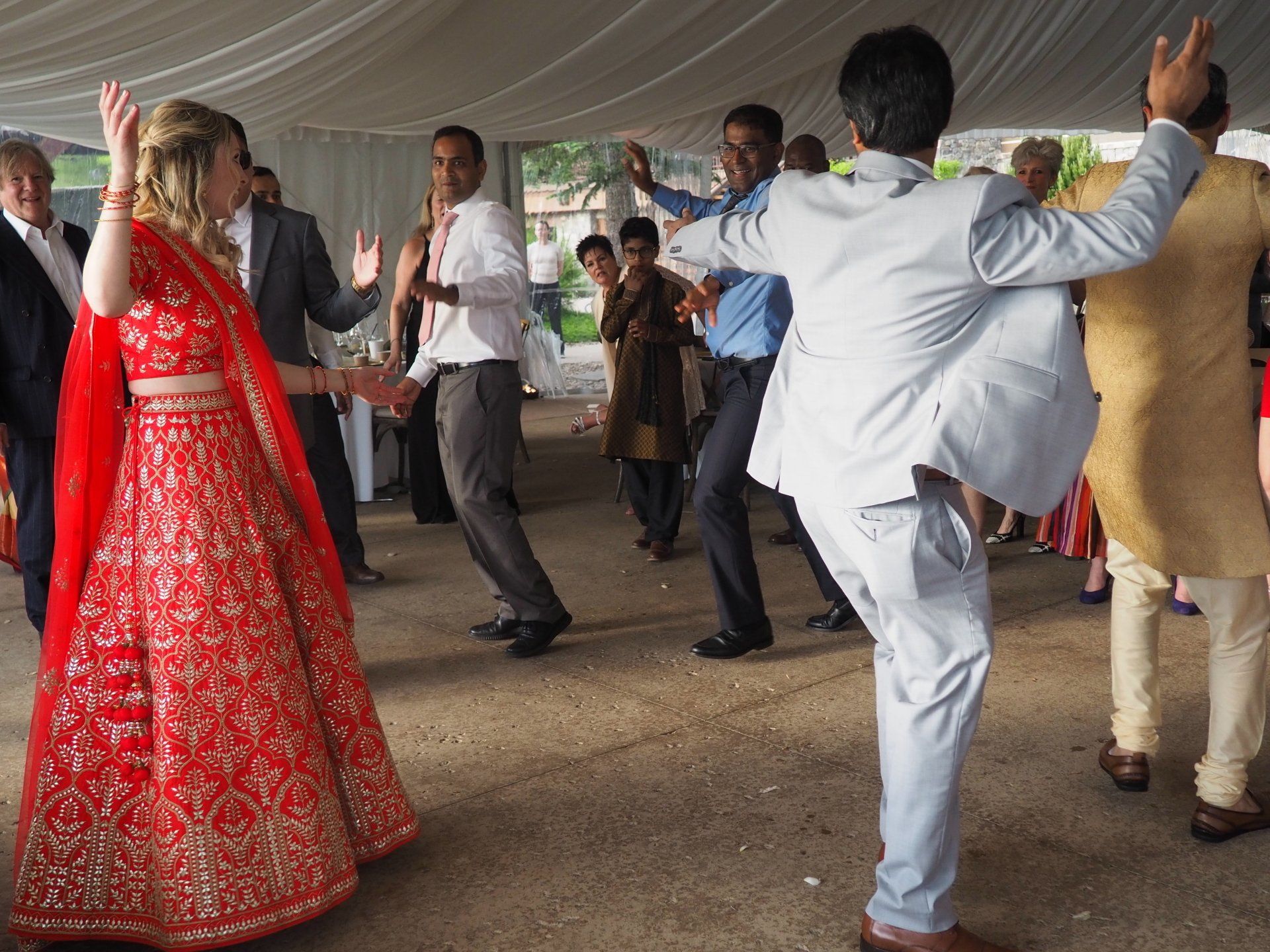 A woman in a red dress is dancing with a man in a suit.