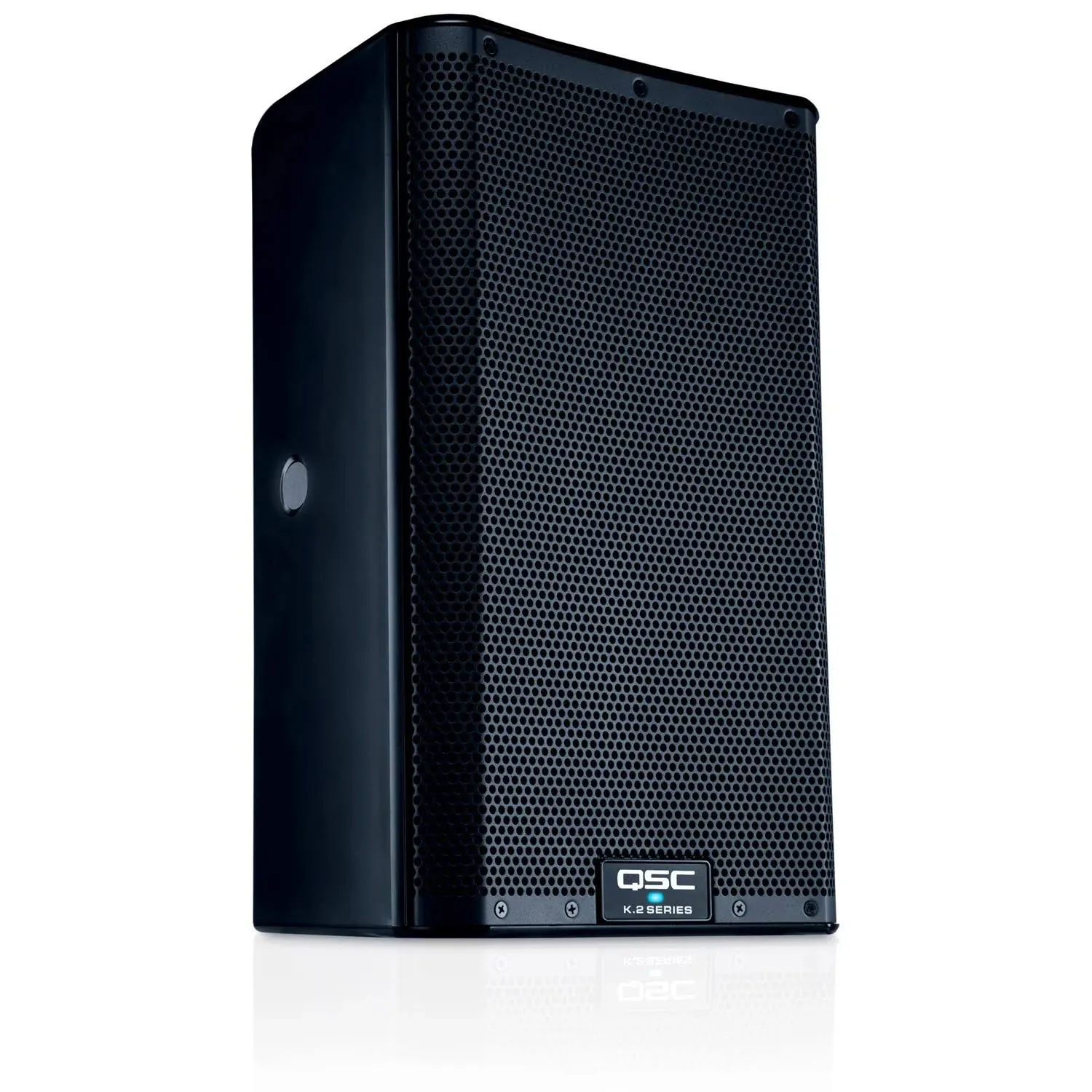 A black qsc speaker is sitting on a white surface.