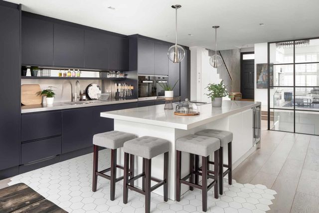 AD Construction NJ - Modern kitchen with navy cabinets, white island, and grey stools.