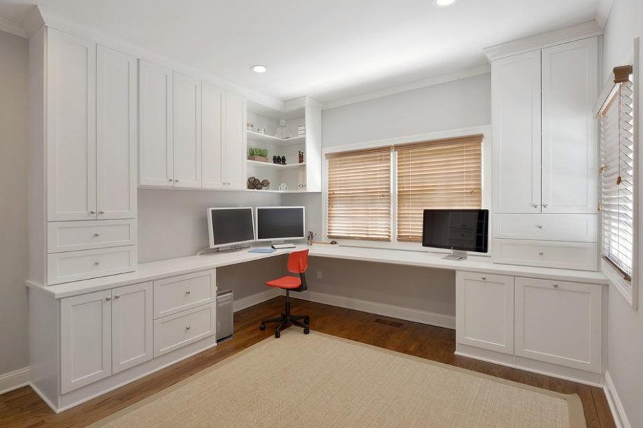AD Construction NJ - White home office with built-in cabinetry, two computer monitors, wood blinds, and an orange chair.