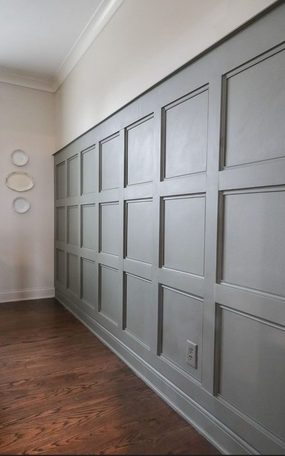 AD Construction NJ - Gray paneled wall with a decorative pattern in a room with wood flooring.